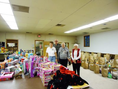 Marlene Uphaus, Dick Fielder, Betty Schneider and Mary Sue Moore surrounded by the groceries for the 2015 Manchester Family Services Christmas shop.