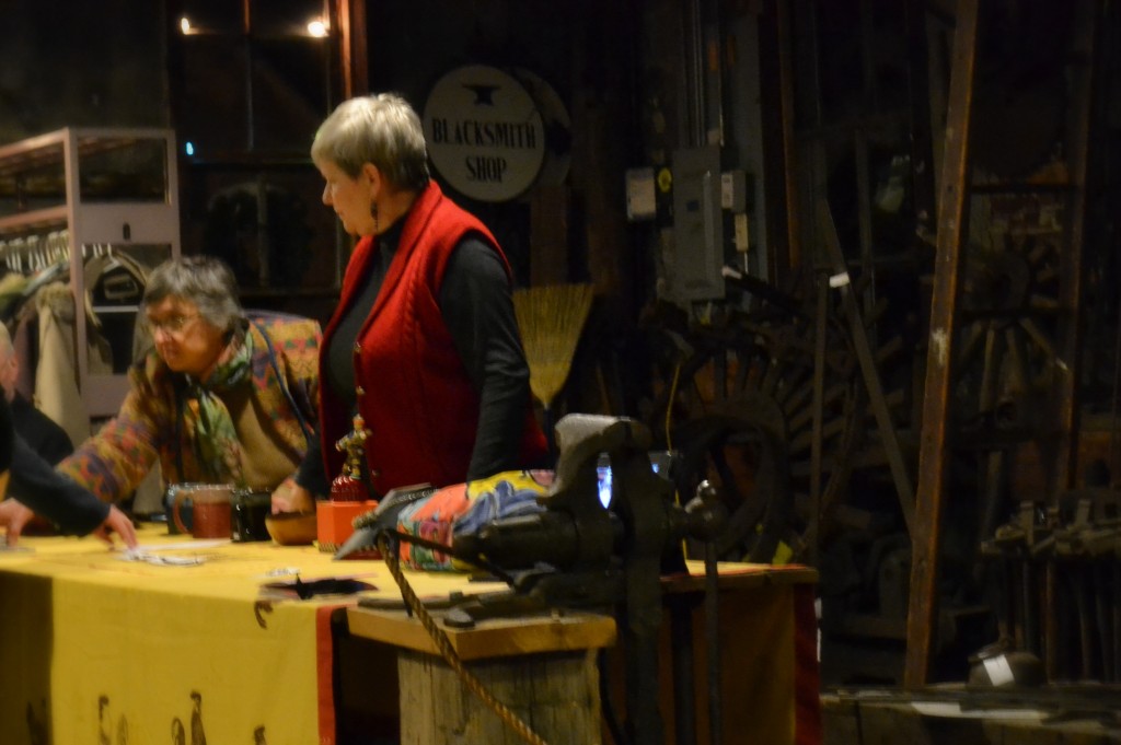 Wild Acorn's Dee Miles, others, conclude silent auction at the CAS/Riverfolk benefit at the blacksmith shop.