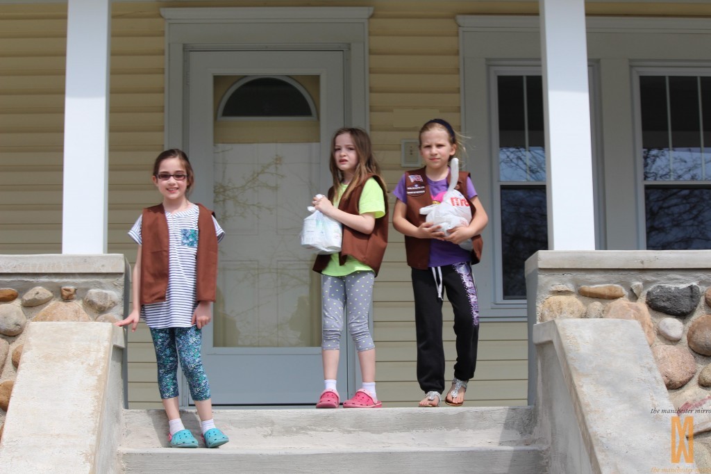 Emma, Amelia, and Miranda taking turns collecting items off of porches.  