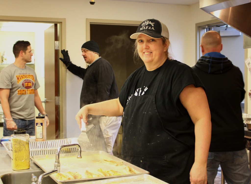 Co-chair Dawn Steele checks the temperature of the baked fish before serving.  Dawn is generally in charge of the kitchen, from prepping all of the foods on Thursday to baking fish all evening on Fridays.  Behind her in black to the left is her husband, Denny Steele.