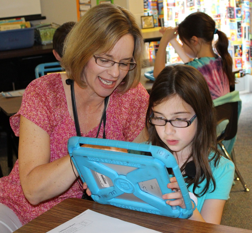 Mrs. Fielder reviews work with Emma Paxton on her IPad.