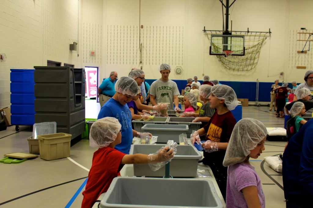 There were many assembly lines like this filling the gym, processing the food, easing hunger one scoop at a time.