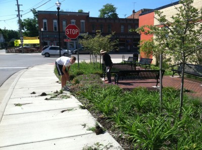 Reese Dresch and DDA member Susan Fielder work on the seating area at Main Street and M-52
