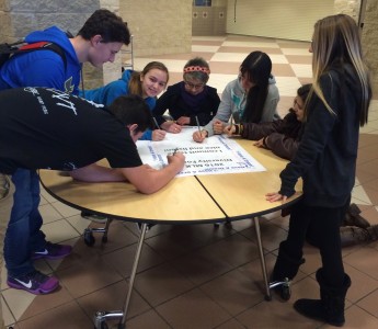Students sign pledge that will hang on the wall in the hallway. Photo courtesy of Manchester High School. 