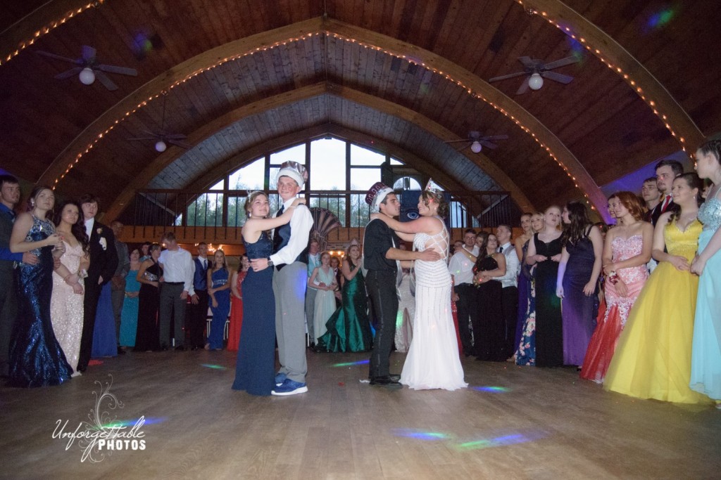 Prom royalty celebrates their dance with their classmates surrounding them. 